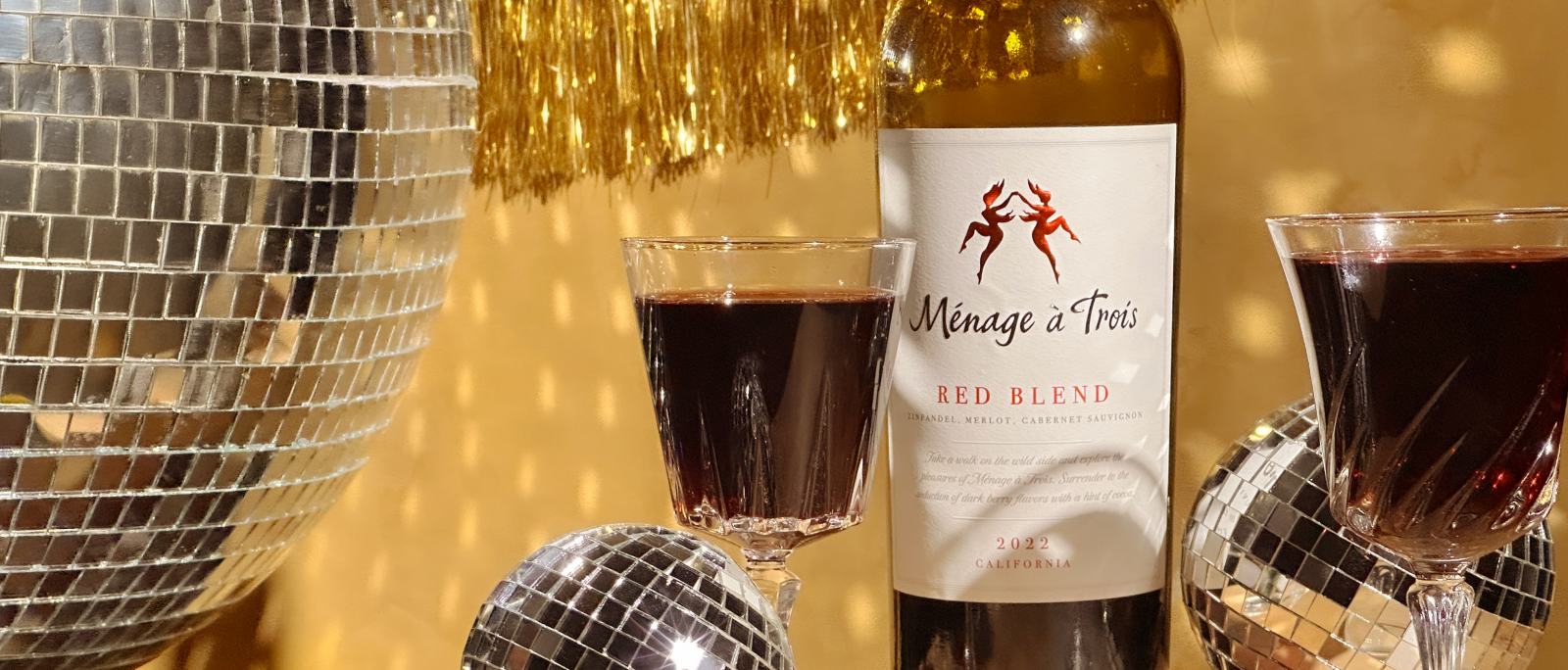 Ménage à Trois red blend bottles with wine glasses and disco balls